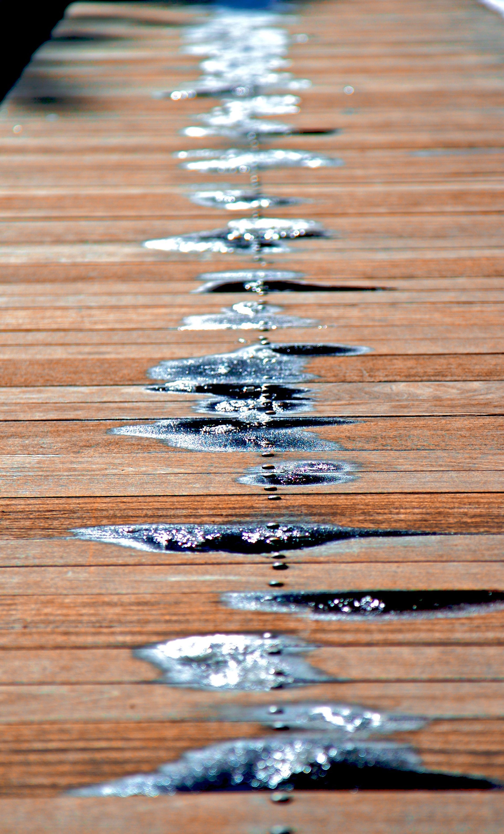Patches of melting ice on a wooden path.