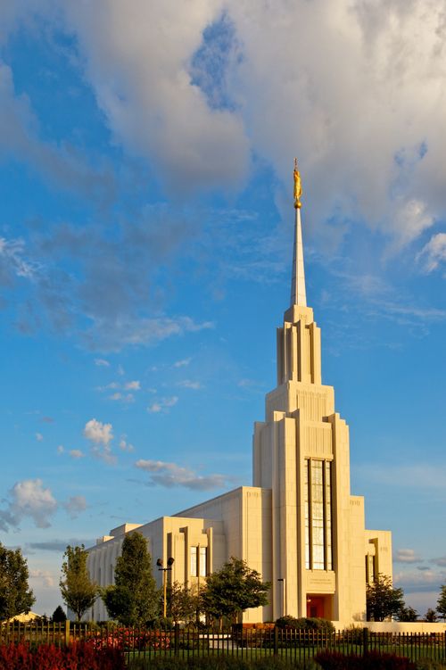 A full view of the Twin Falls Idaho Temple during the day, including the grounds with trees and flowers.