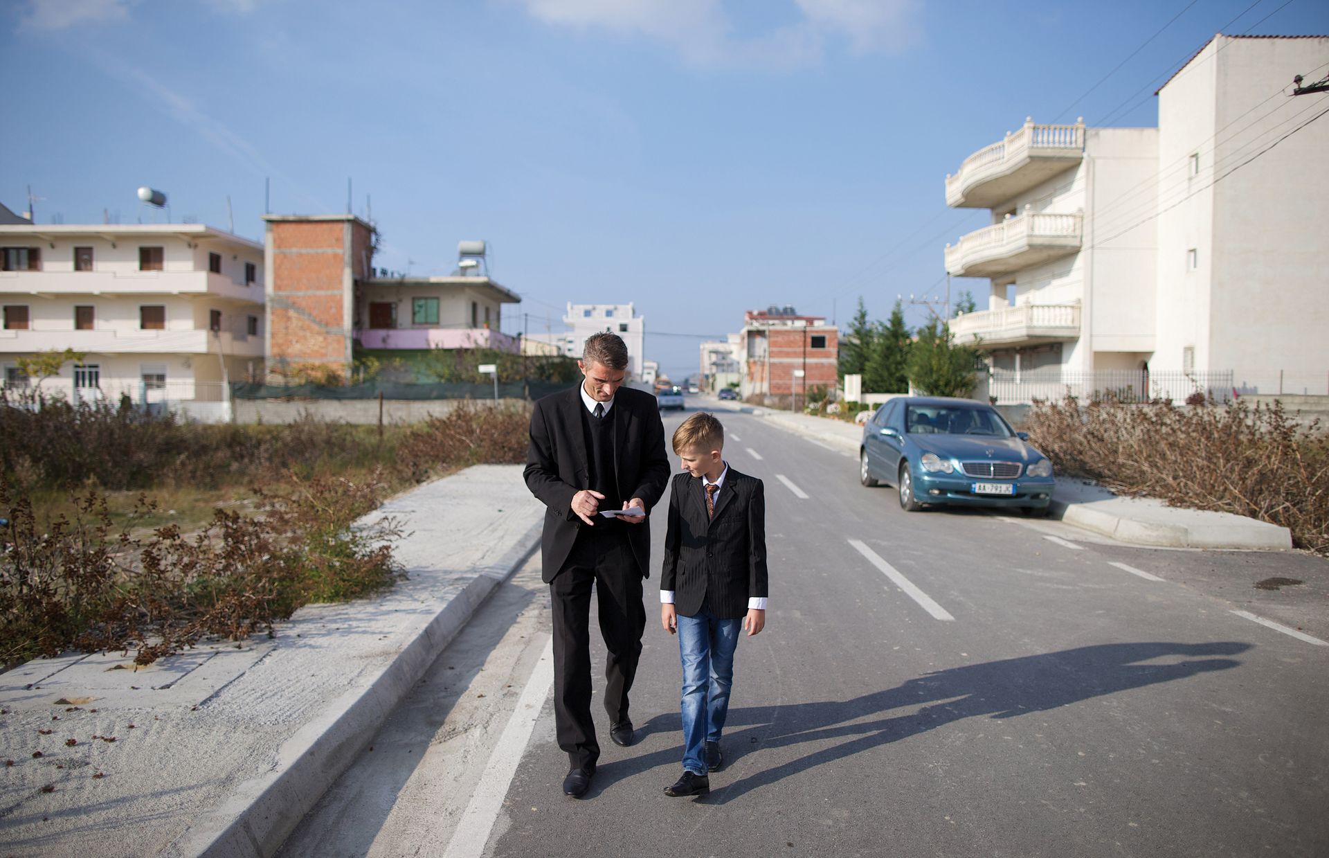 Ilir and his son walk through the streets of Durrës.