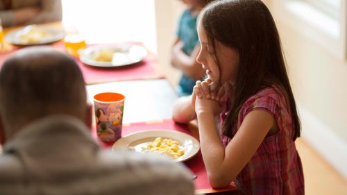 girl praying at mealtime