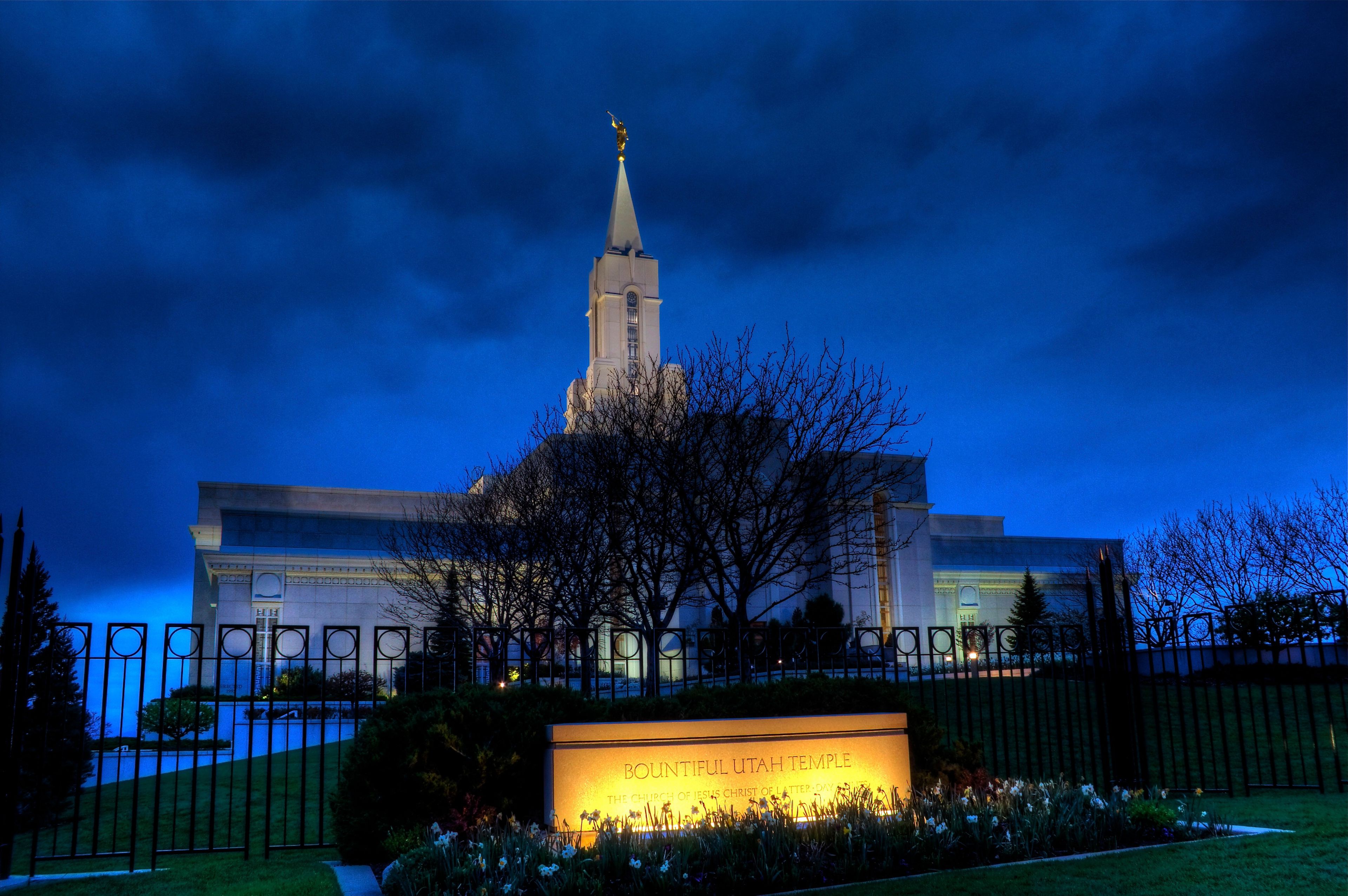 An exterior view of the Bountiful Utah Temple lit up at night.  