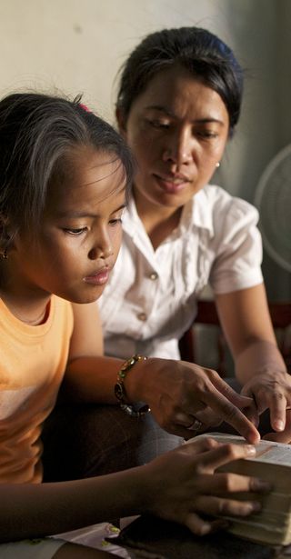 mother studying scriptures with young daughter