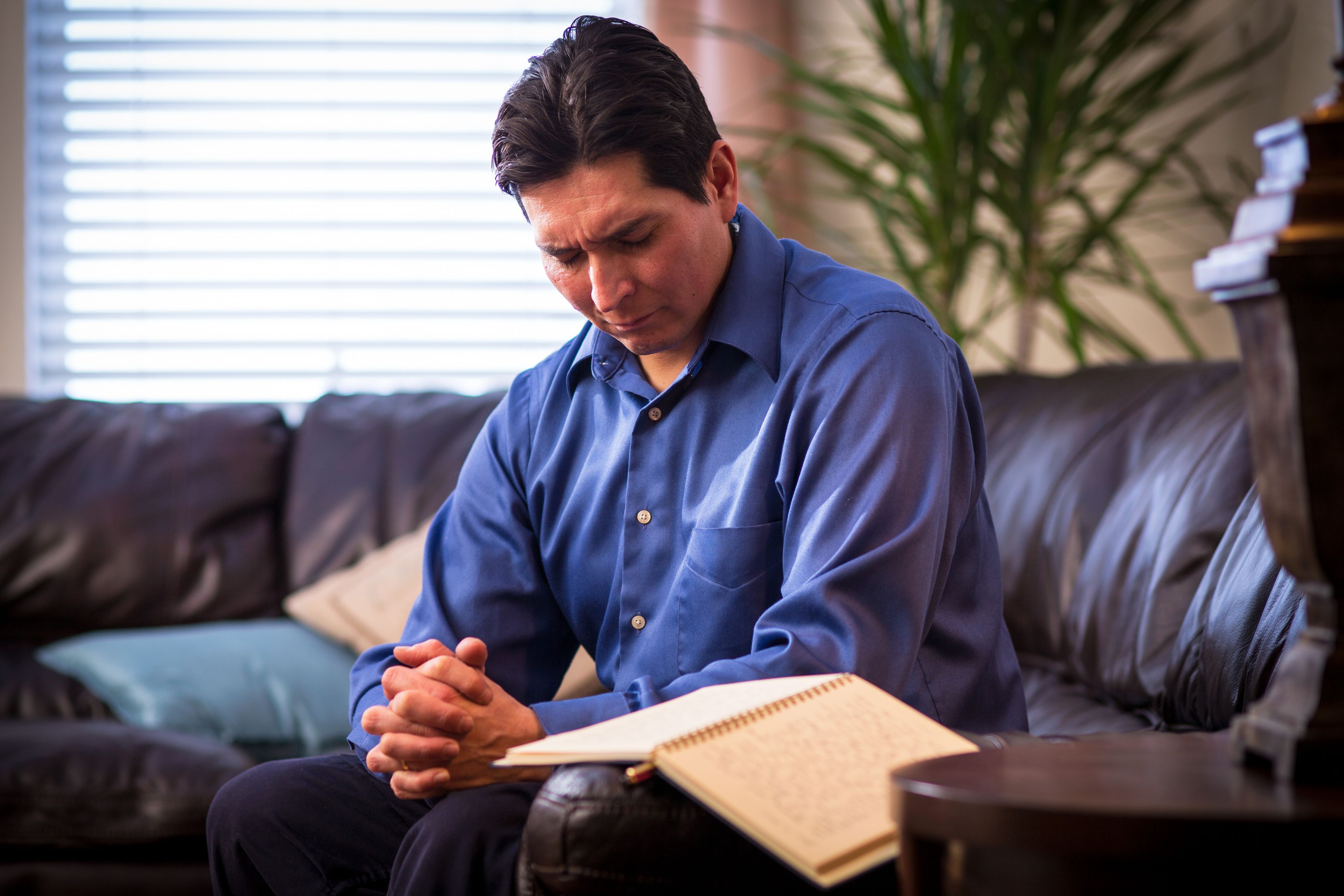 A man prays after writing in his journal.