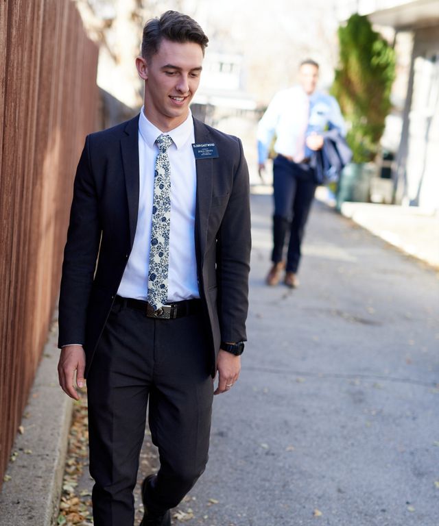 A missionary models appropriate dress and attire. He is wearing an approved suit, tie, pants, and shoes.