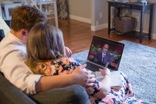 Young couple watching general conference on a laptop