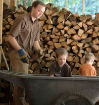 man and boys with woodpile