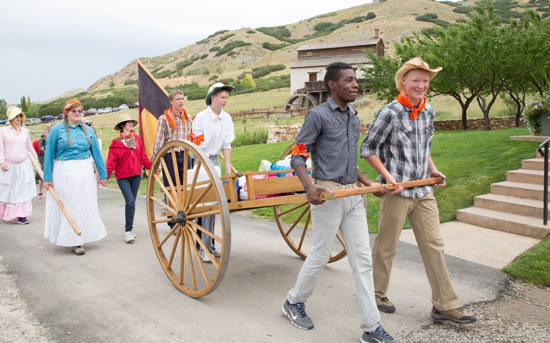 A group of youth pull a handcart during trek.