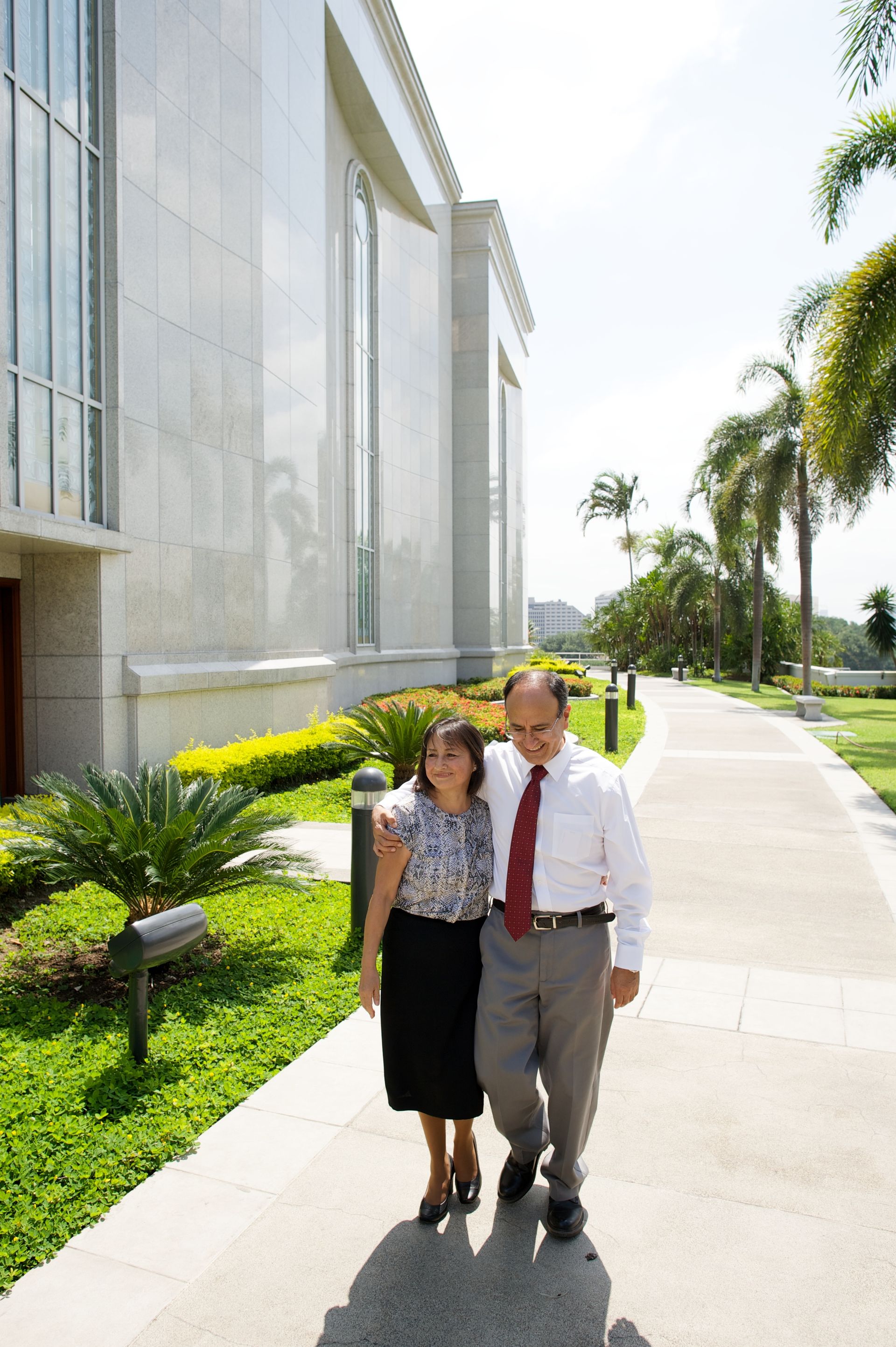 A husband and wife walk close together outside of the Guayaquil Ecuador Temple.