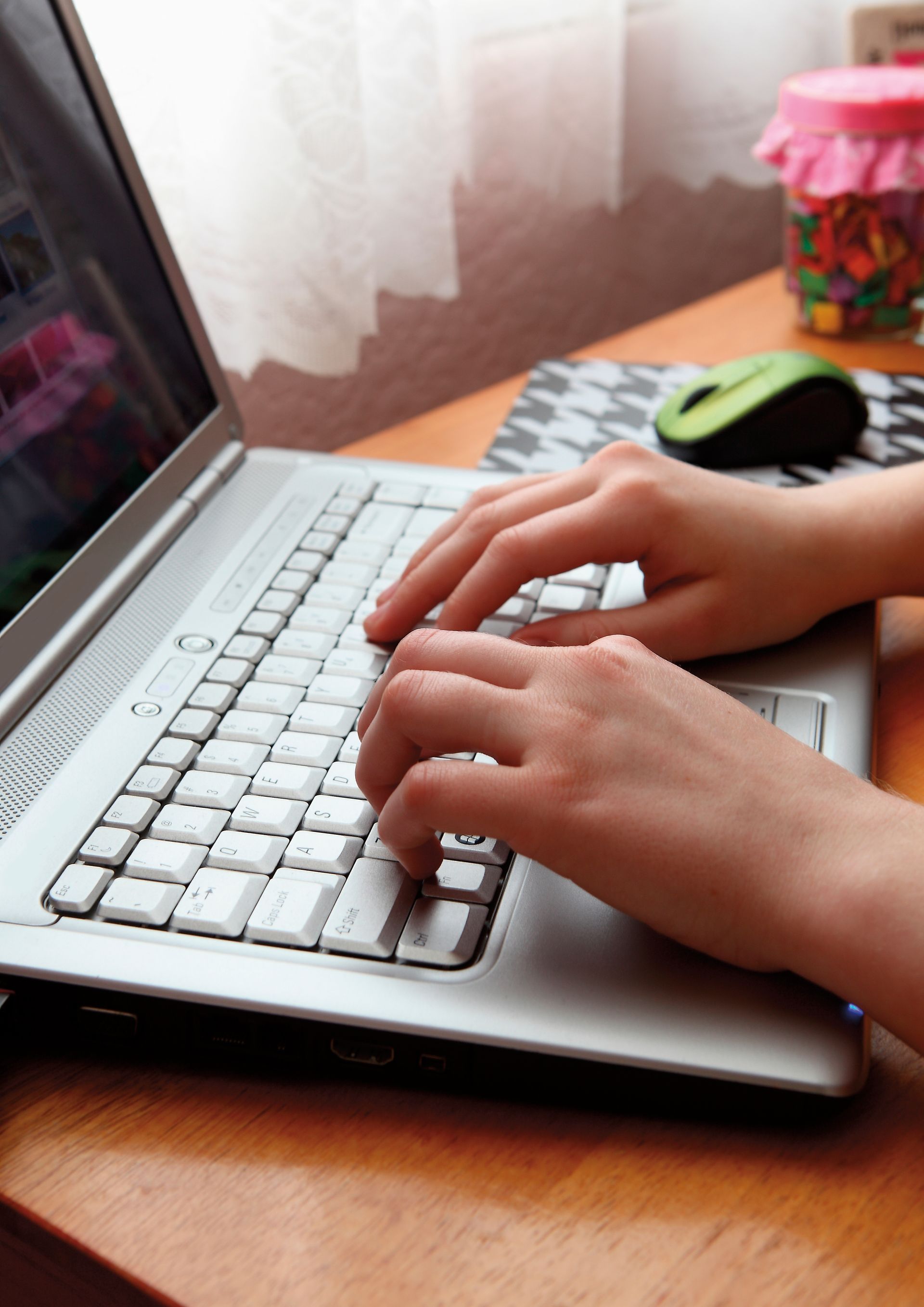 Hands are seen typing on a laptop.