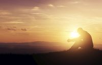 man sitting with sun behind him