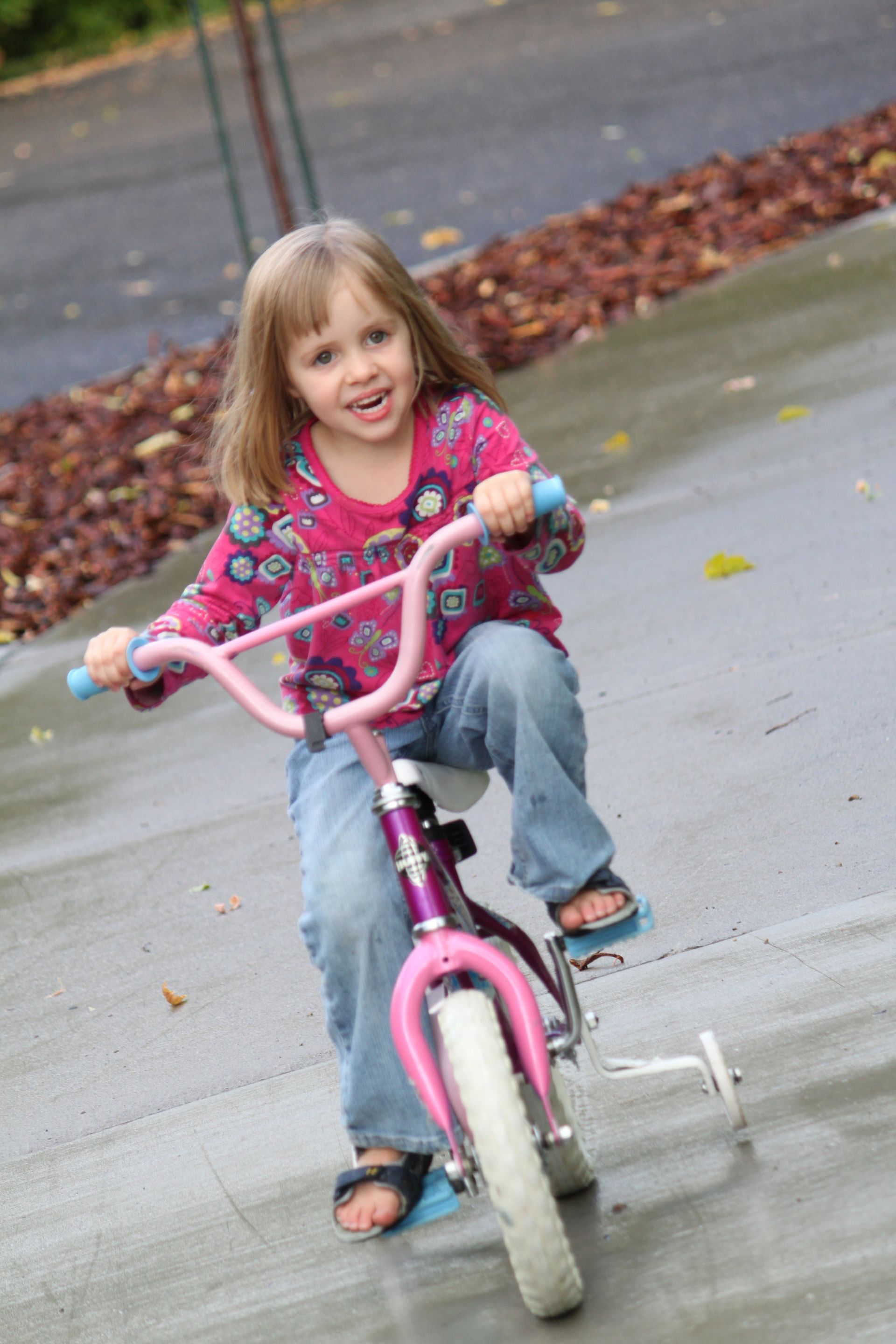 A portrait of a young girl on a bike.