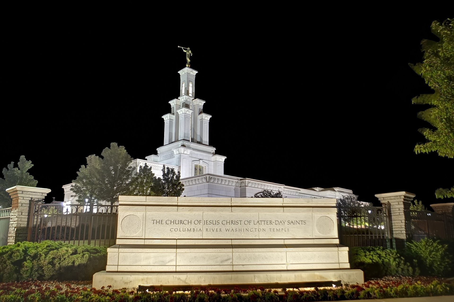 The temple name sign of the Columbia River Washington Temple is lit up at night.