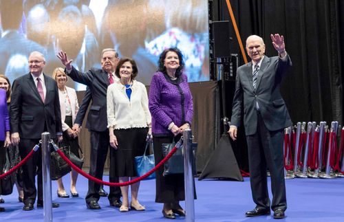 Le président Nelson et d’autres personnes saluent les saints de Hong Kong (Chine)