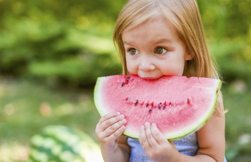 little girl eating watermelon