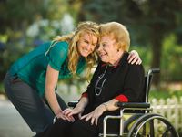 younger woman hugging elderly woman