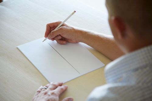 Man writing on a piece of paper.