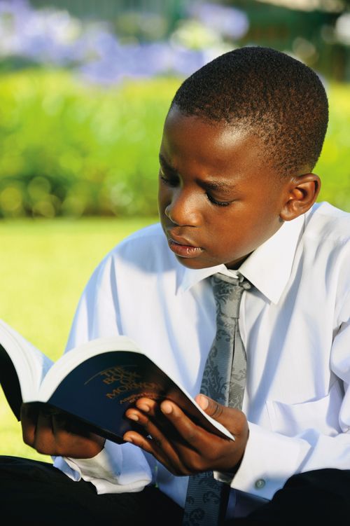 A young boy reading the scriptures.