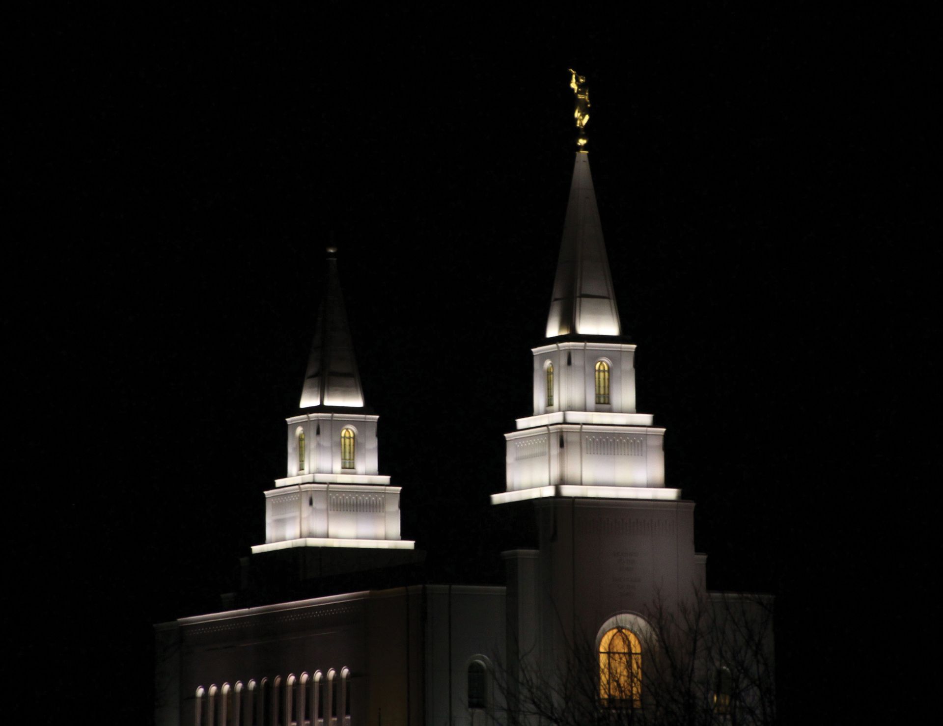 The Kansas City Missouri Temple lit up at night, including spires and windows.