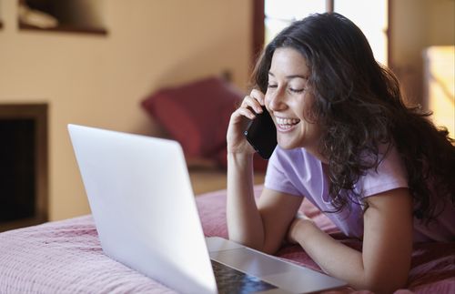 Woman looking at computer and talking on the phone