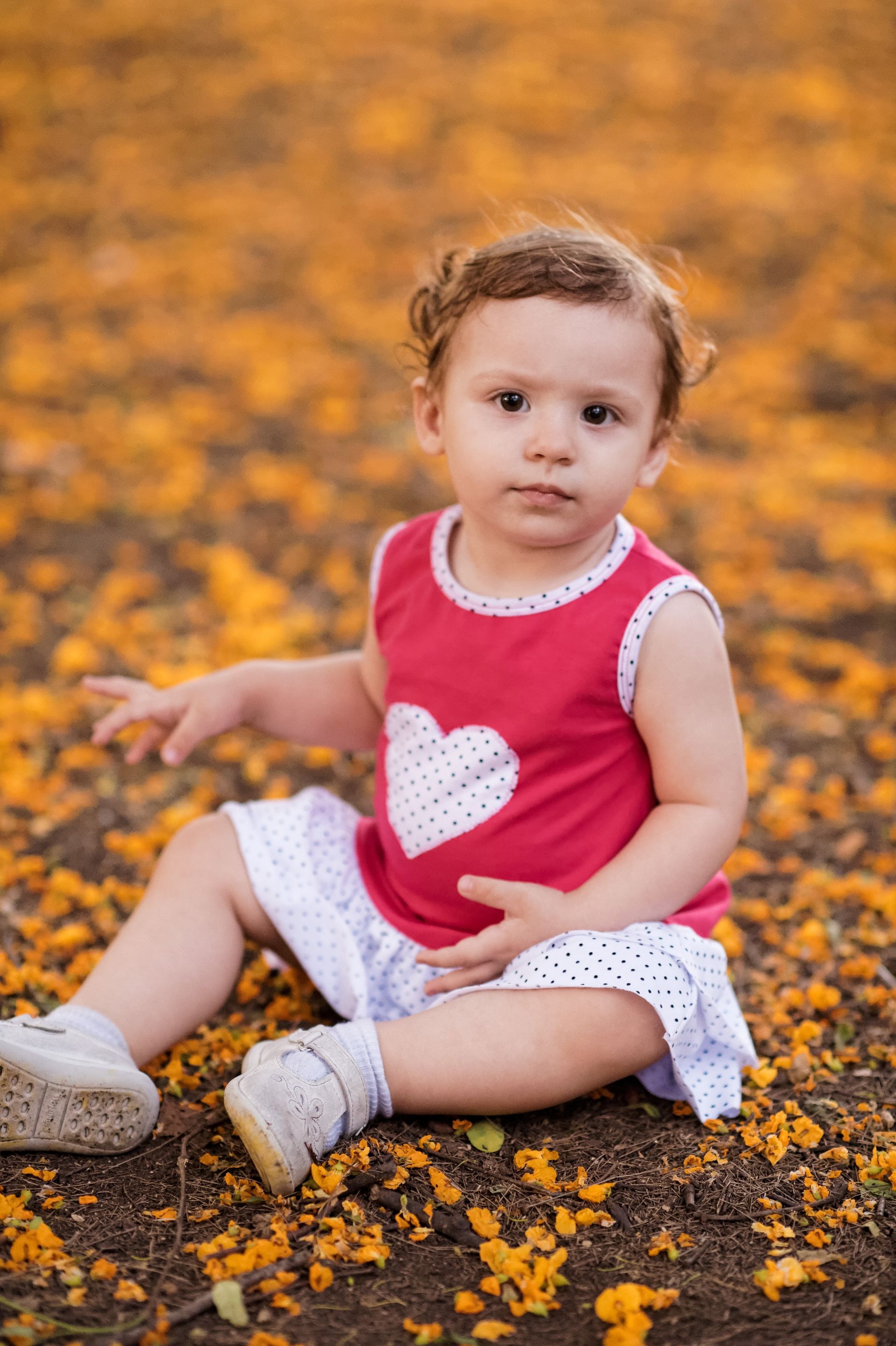 A toddler girl in Argentina wearing a dress with a heart on it.