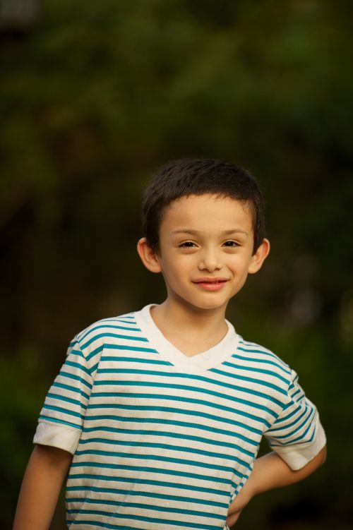 A portrait of a young boy wearing a white and blue striped shirt.