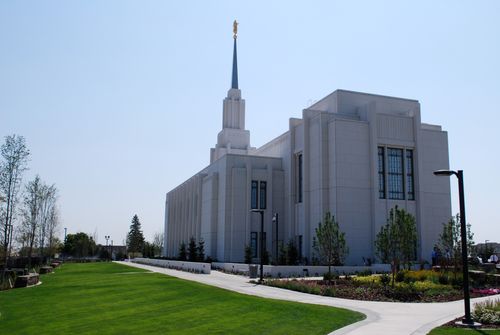 The back of the Twin Falls Idaho Temple, with the grounds lined with trees and bushes.