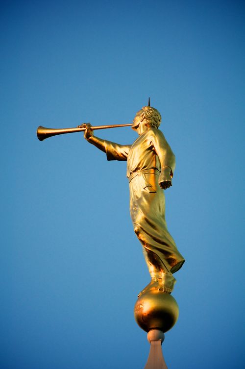 A view of the angel Moroni from the side, with a clear, deep blue sky in the background.