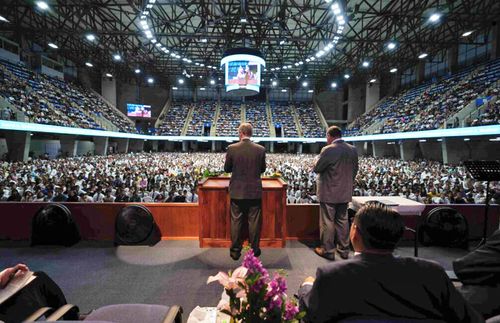 Elder Bednar speaking in front of large crowd