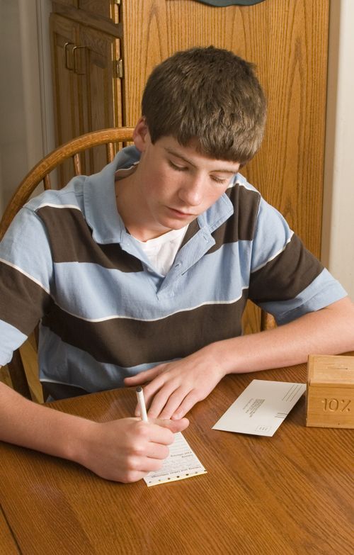 young man writing on donation slip