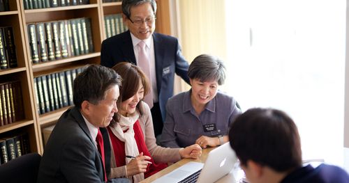 senior couple at a computer with others