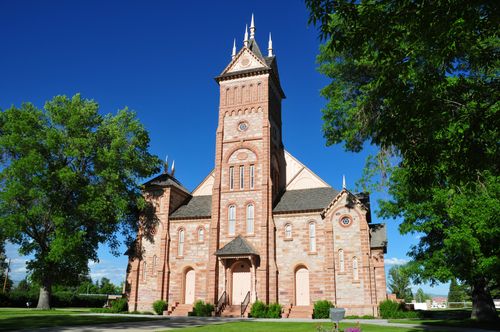 A front view of the historic Bear Lake Stake Tabernacle in Paris, Idaho, consisting of brick in a variety of colors with a large steeple in the front center.