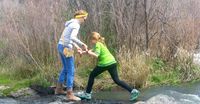 girls crossing stream