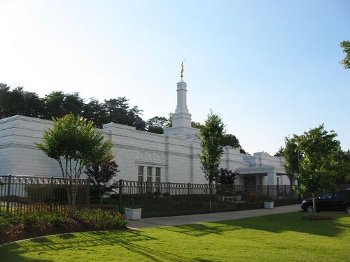 A side view of the Birmingham Alabama Temple on a sunny day, with green lawns on the temple’s grounds.