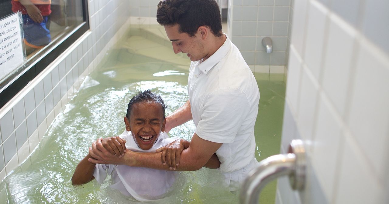 A boy being baptized in a baptismal font in a church building in Madagascar.