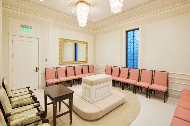Photo of the sealing room in the Yigo Guam Temple. Image shows a chandeliers in the middle of the room with an altar underneath. Around are chairs.