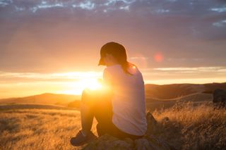 young woman watching sunset