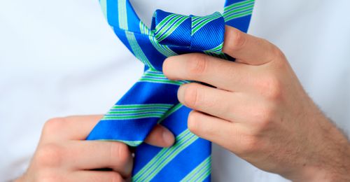 young man tying a tie