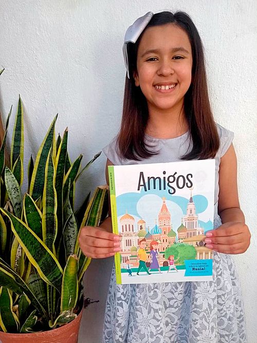 girl holding copy of the Friend magazine in Spanish