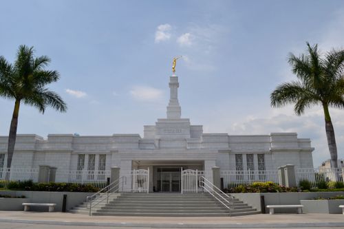 The Guadalajara Mexico Temple entrance during the daytime, with palm trees on either side.
