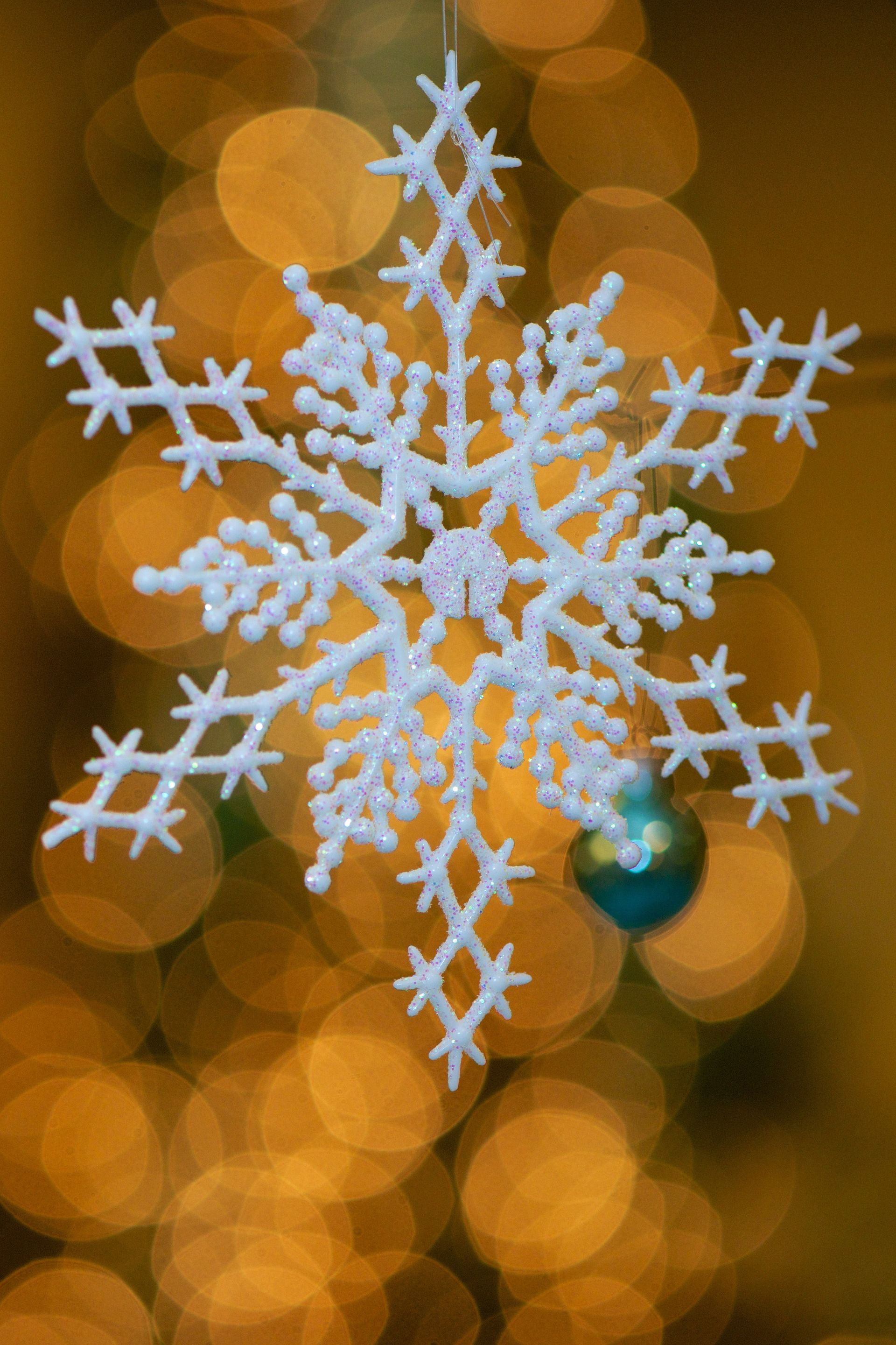 A Christmas tree ornament in the shape of a snowflake.