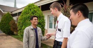 միսիոներները սեղմում են տղամարդու ձեռքը 