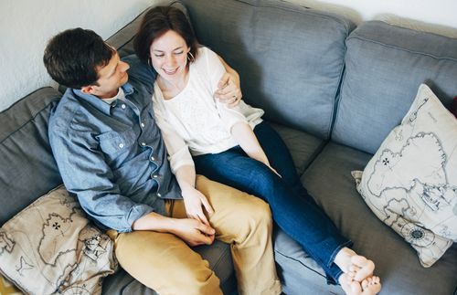 husband and wife sitting together on couch