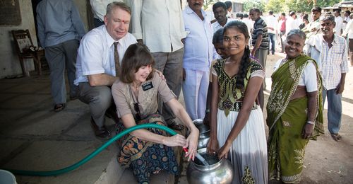 senior missionary couple helping to fill waterpots in India