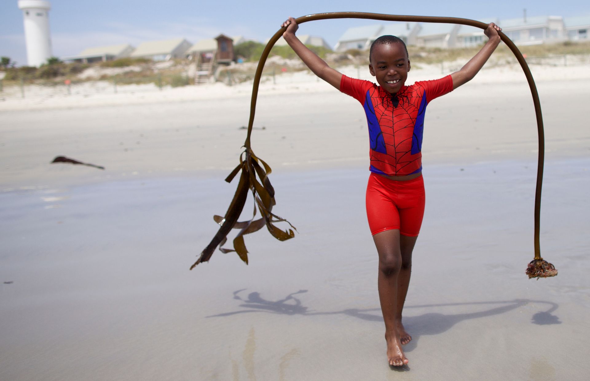 Tendai hoists a strand of kelp during a family trip to the beach. Tendai recently turned eight years old and was excited to be baptized and confirmed a member of the Church.