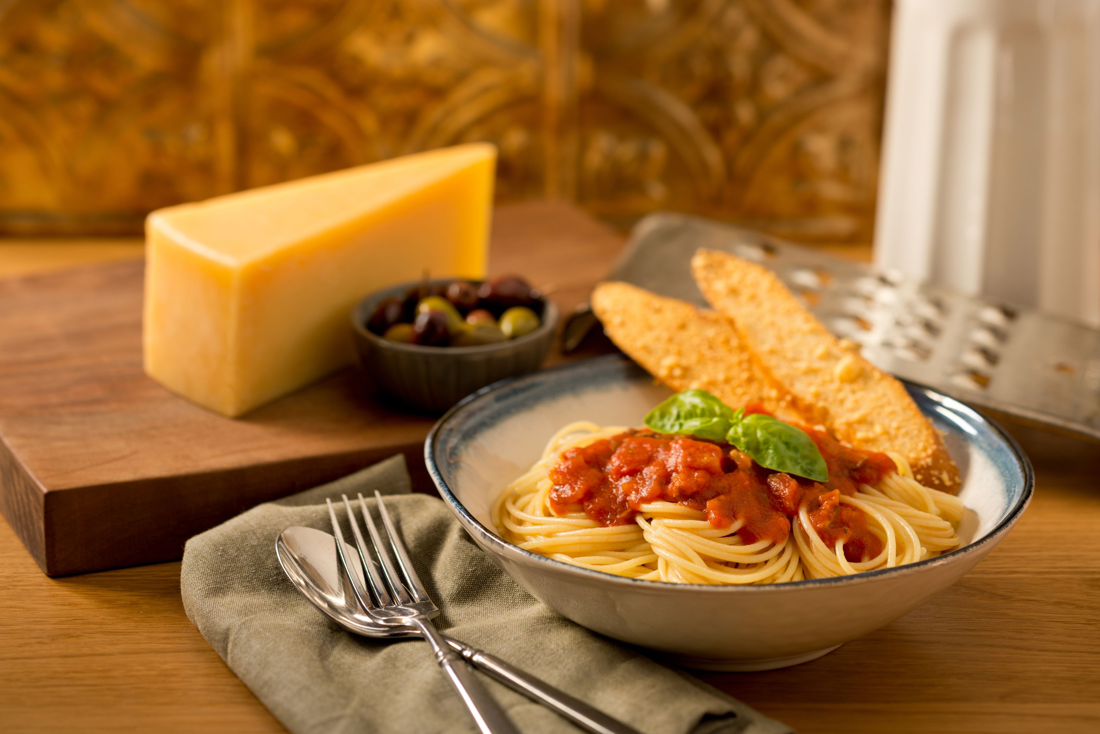 Spaghetti, bread, and cheese for a pasta meal.
