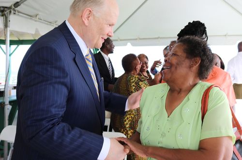 Elder Dale G. Renlund shaking hands with woman at event in Barbados