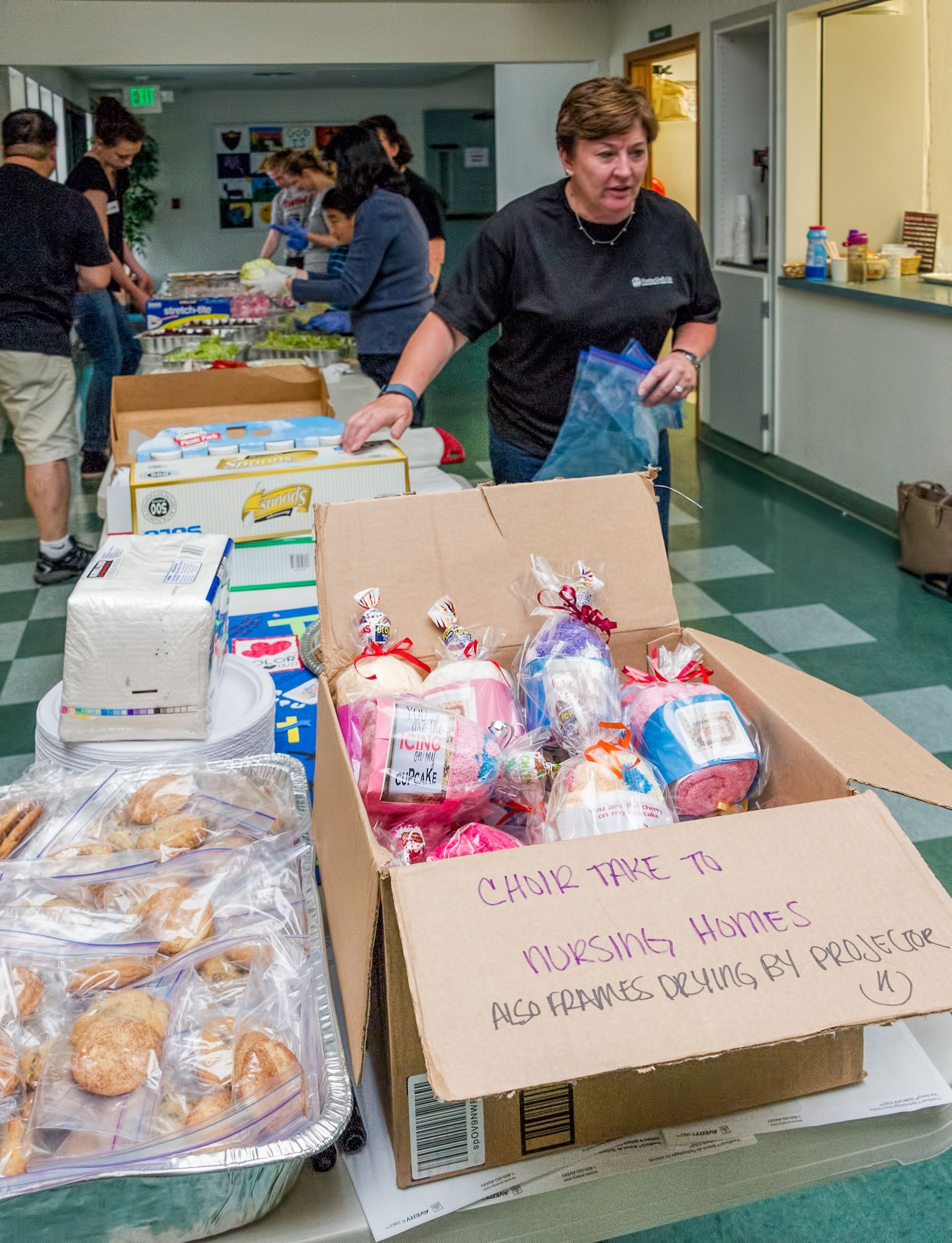 A group of volunteers assembling food at a nursing home.