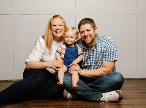 Sonja Porter sits on the floor with her husband and son for a family portrait.