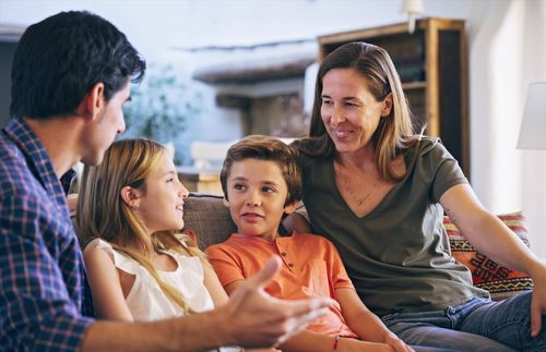 a family sitting together on a couch and having a discussion