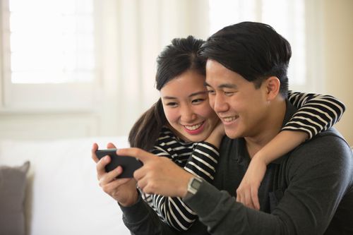 smiling couple looking at phone together